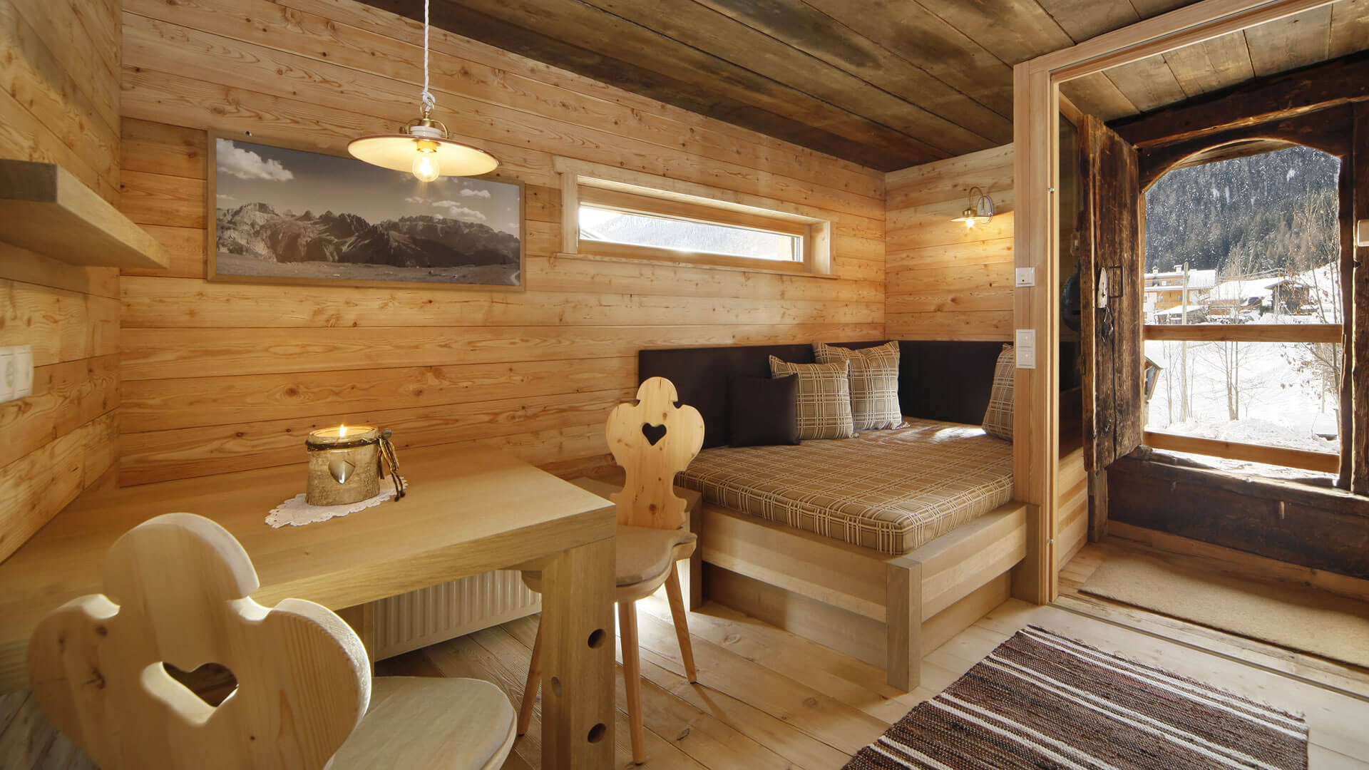 The historical Chalet Gratznhäusl Cozy wooden interior with sofa, table, and view of snowy mountains